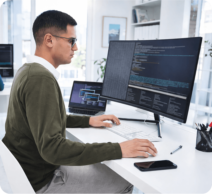 Man Using Laptop with Monitor